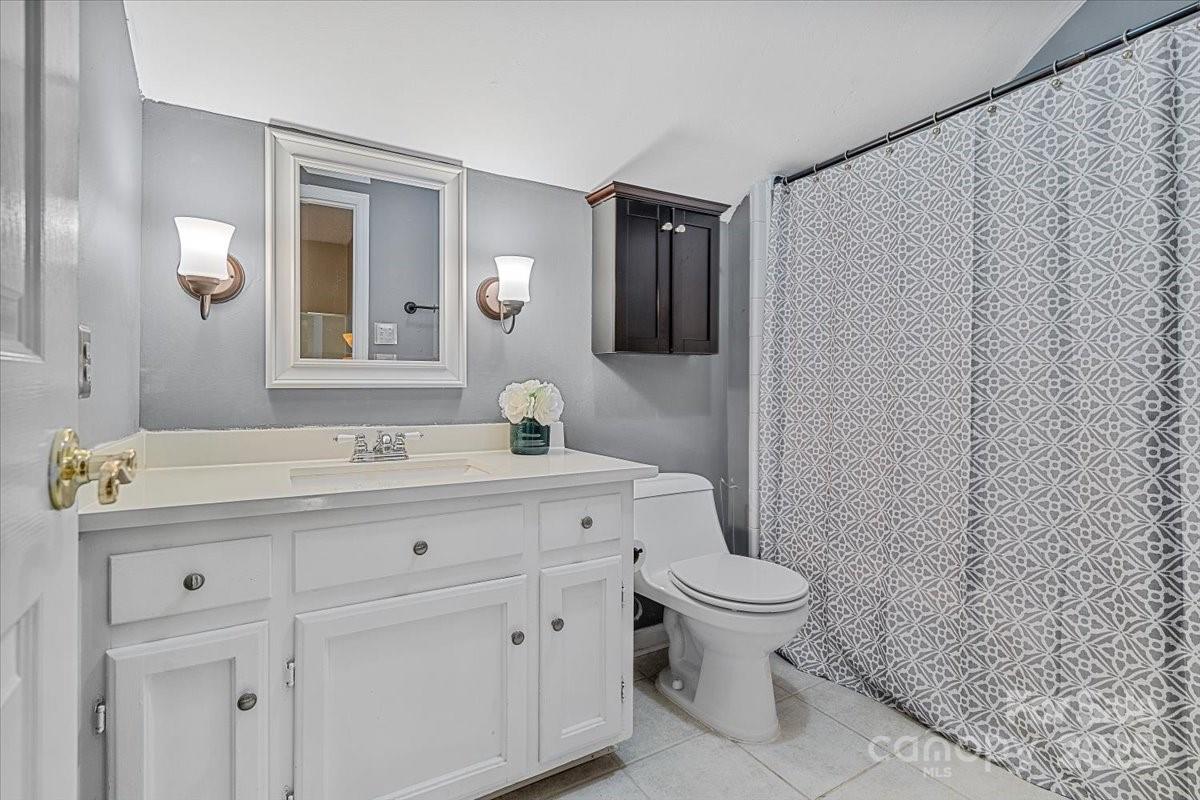 5084 Mariana Court Tega Cay, SC 29708 - Photo 14 of 33 a bathroom with a granite countertop sink a toilet and a mirror