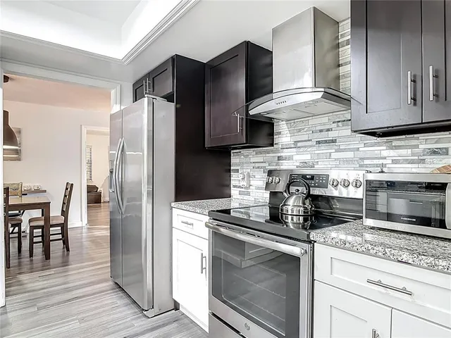 a kitchen with stainless steel appliances granite countertop a refrigerator stove and microwave