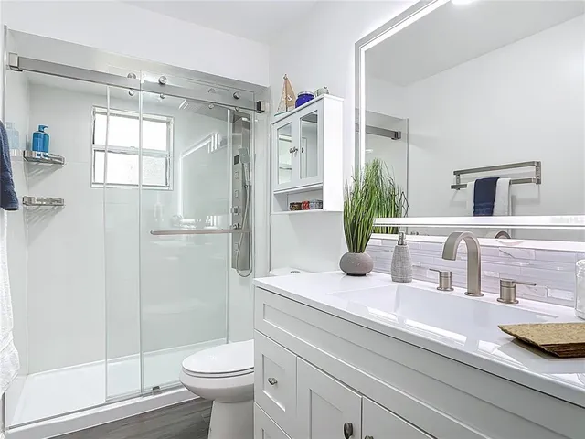 a bathroom with a sink a toilet and shower