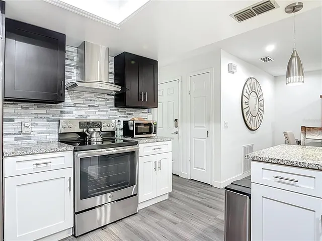 a kitchen with stainless steel appliances granite countertop a stove and a microwave