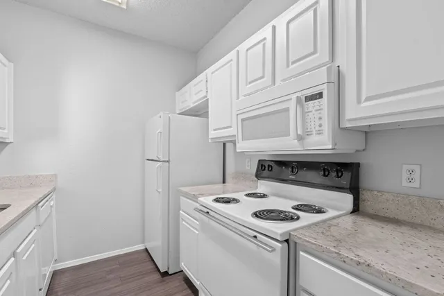 a kitchen with a sink cabinets and a wooden floor