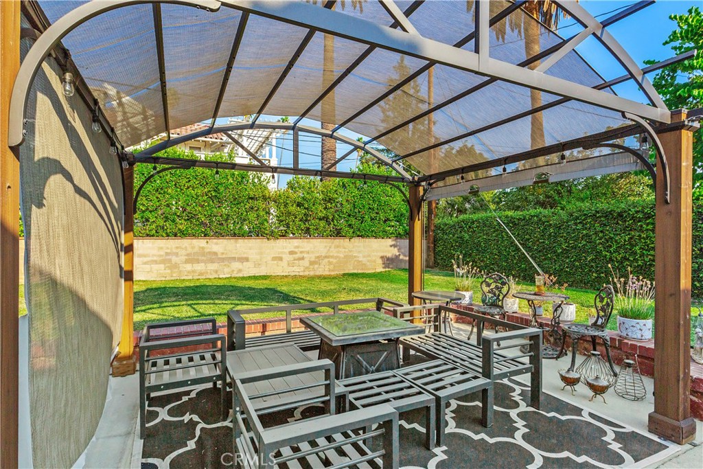 206 Melrose Avenue Monrovia, CA 91016 - Photo 33 of 35 a view of a patio with table and chairs under an umbrella with a small yard
