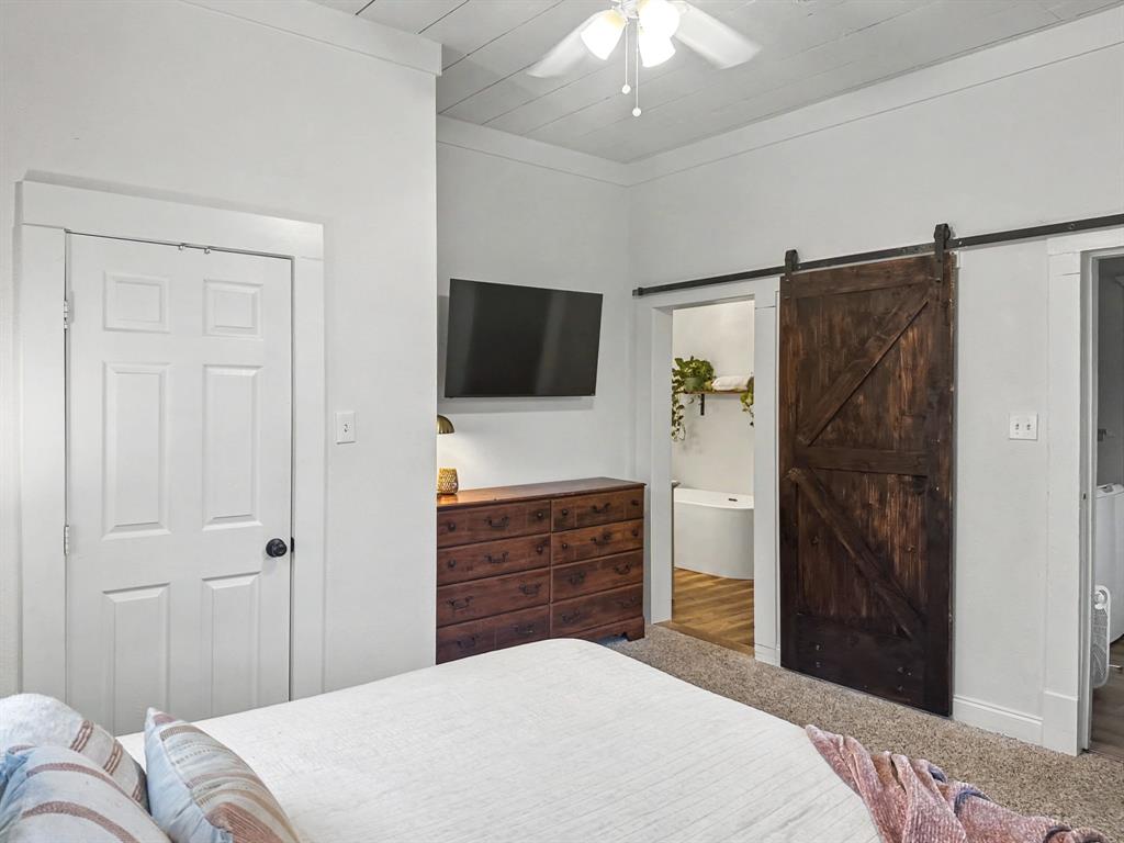 1517 Cumberland Avenue Waco, TX 76708 - Photo 15 of 30 a bedroom with a bed and a flat tv screen on dresser