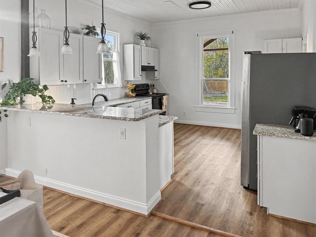 1517 Cumberland Avenue Waco, TX 76708 - Photo 9 of 30 a view of a kitchen with kitchen island a sink wooden floor and a counter top space