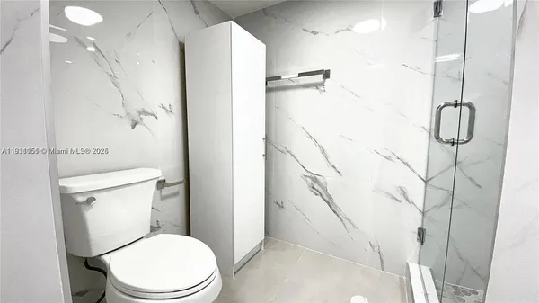 a white toilet sitting next to a bathroom sink