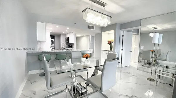 a kitchen with stainless steel appliances kitchen island granite countertop a table and chairs in it