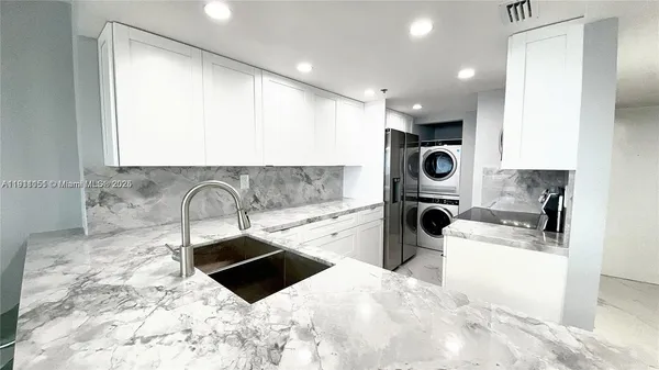 a kitchen with stainless steel appliances a sink a stove a microwave a sink and cabinets