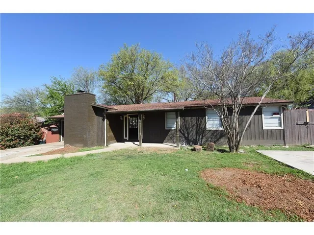 a front view of a house with a yard and trees