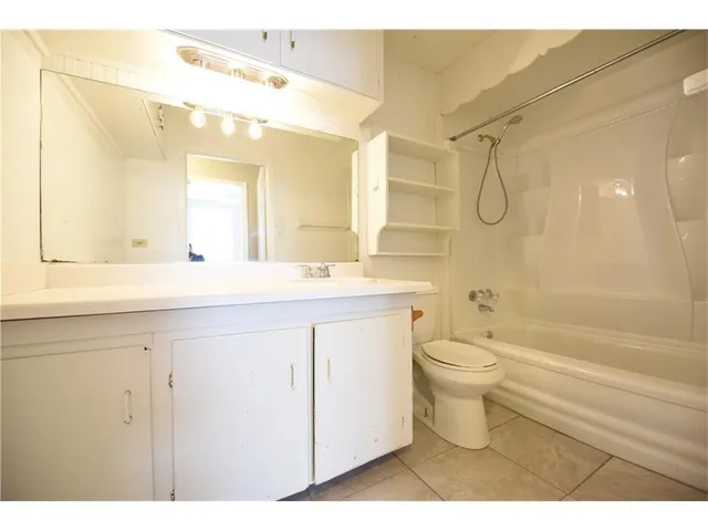 a bathroom with a double vanity sink toilet mirror and shower