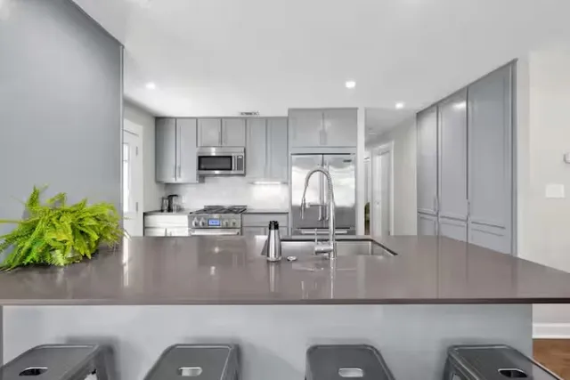 a kitchen with kitchen island a counter top space a sink and appliances