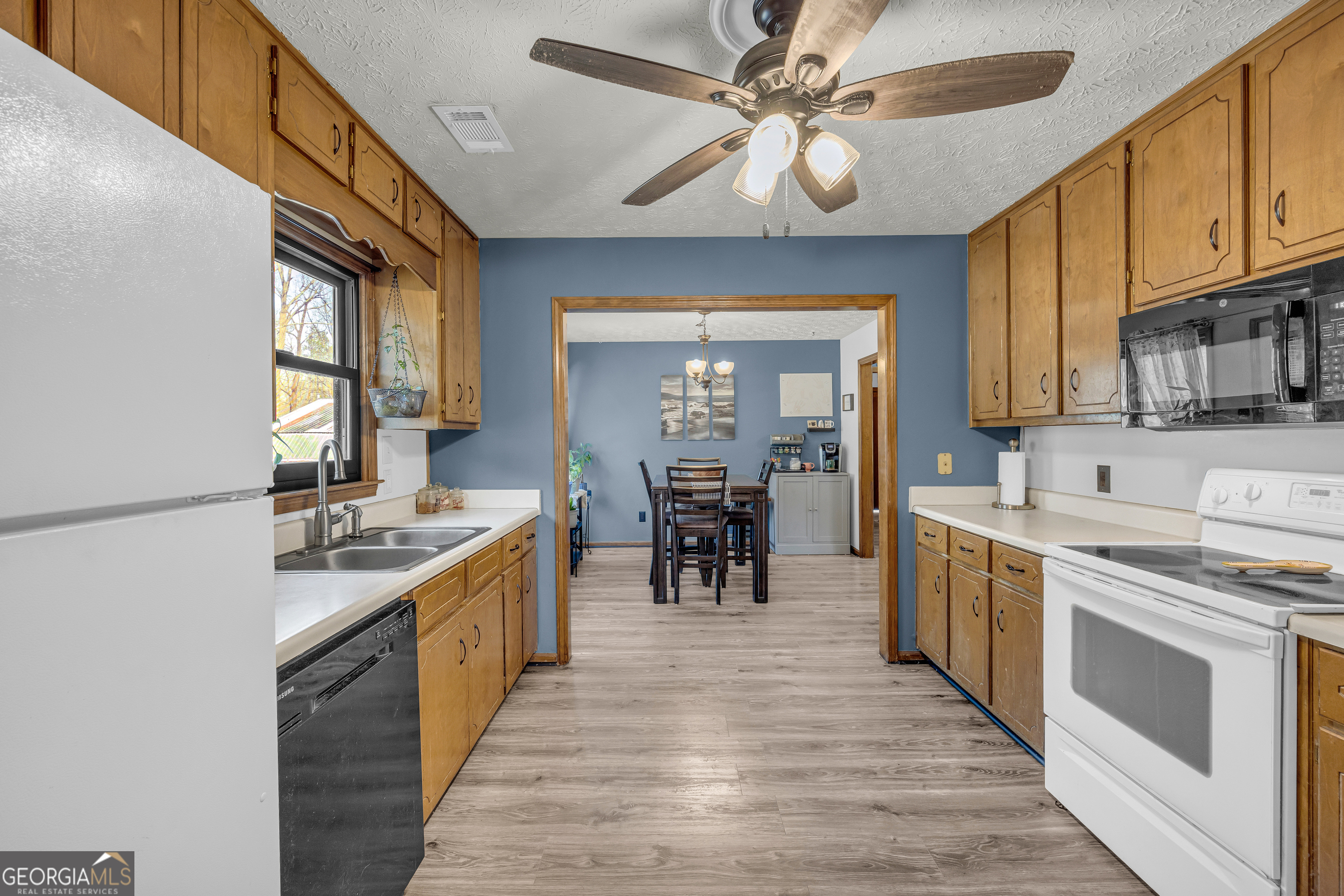 233 Kennedy Sells Road Northwest Auburn, GA 30011 - Photo 23 of 52 a large kitchen with stainless steel appliances granite countertop a stove oven a sink dishwasher a dining table and chairs with wooden floor