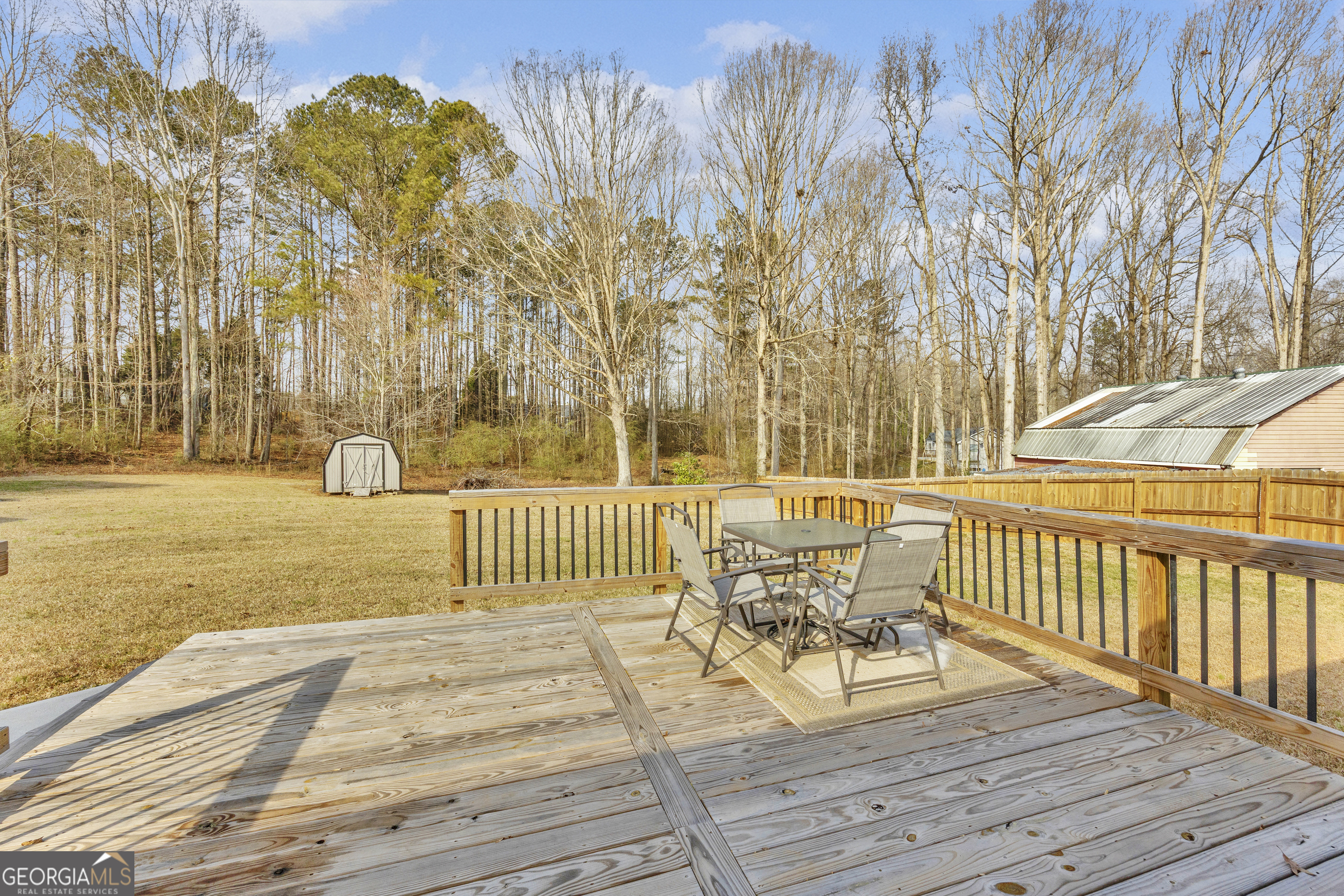 233 Kennedy Sells Road Northwest Auburn, GA 30011 - Photo 38 of 52 a view of a deck with table and chairs with wooden floor and fence