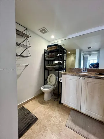 a living room with furniture a flat screen tv and kitchen view