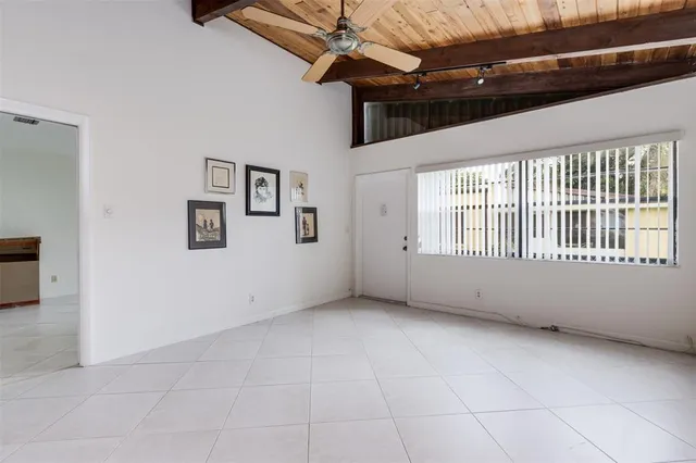 an empty room with a window and a ceiling fan