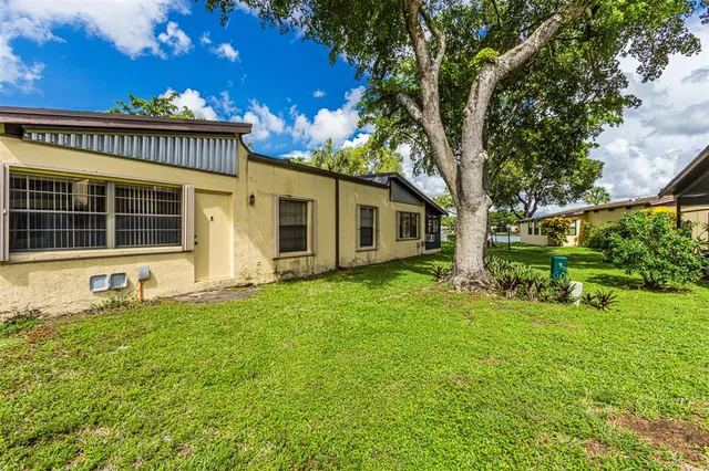 a view of pool with large trees and wooden fence
