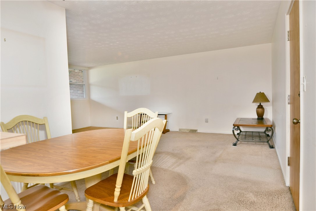 2980 North River Road Northeast, Unit E3 Warren, OH 44483 - Photo 10 of 27 Carpeted dining room with a textured ceiling