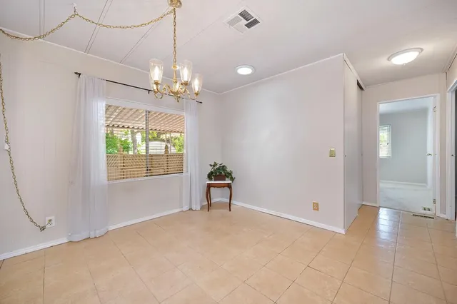 a view of a livingroom with a chandelier fan and windows