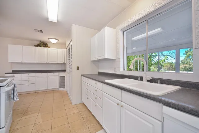 a kitchen with a sink window and cabinets
