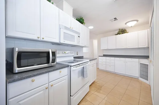 a kitchen with stainless steel appliances granite countertop white cabinets a sink and dishwasher