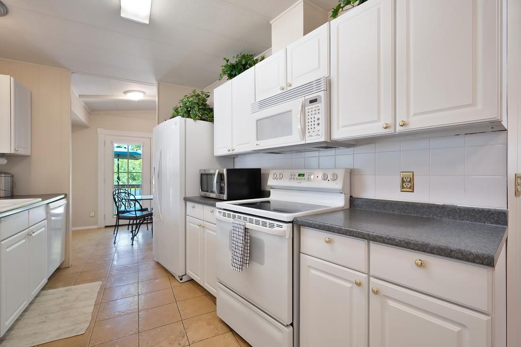 6374 Brodie Drive Newcastle, CA 95658 - Photo 20 of 50 a kitchen with white cabinets and appliances