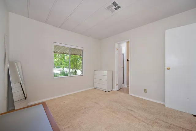 an empty room with a window and a ceiling fan