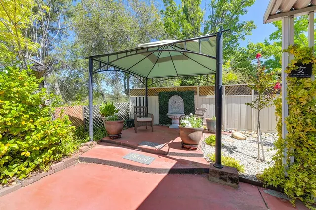 a view of a patio with table and chairs under an umbrella