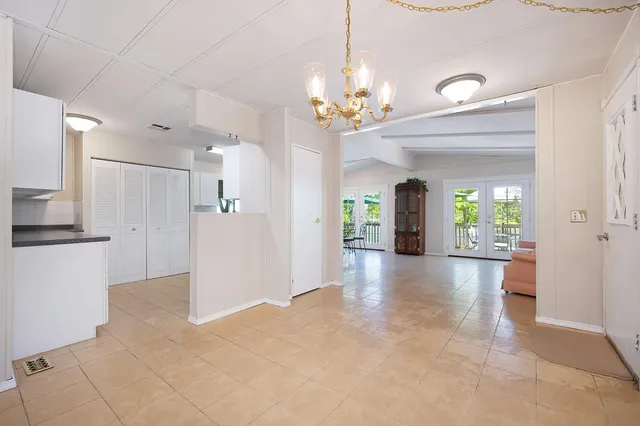 a view of a hallway with furniture and a chandelier