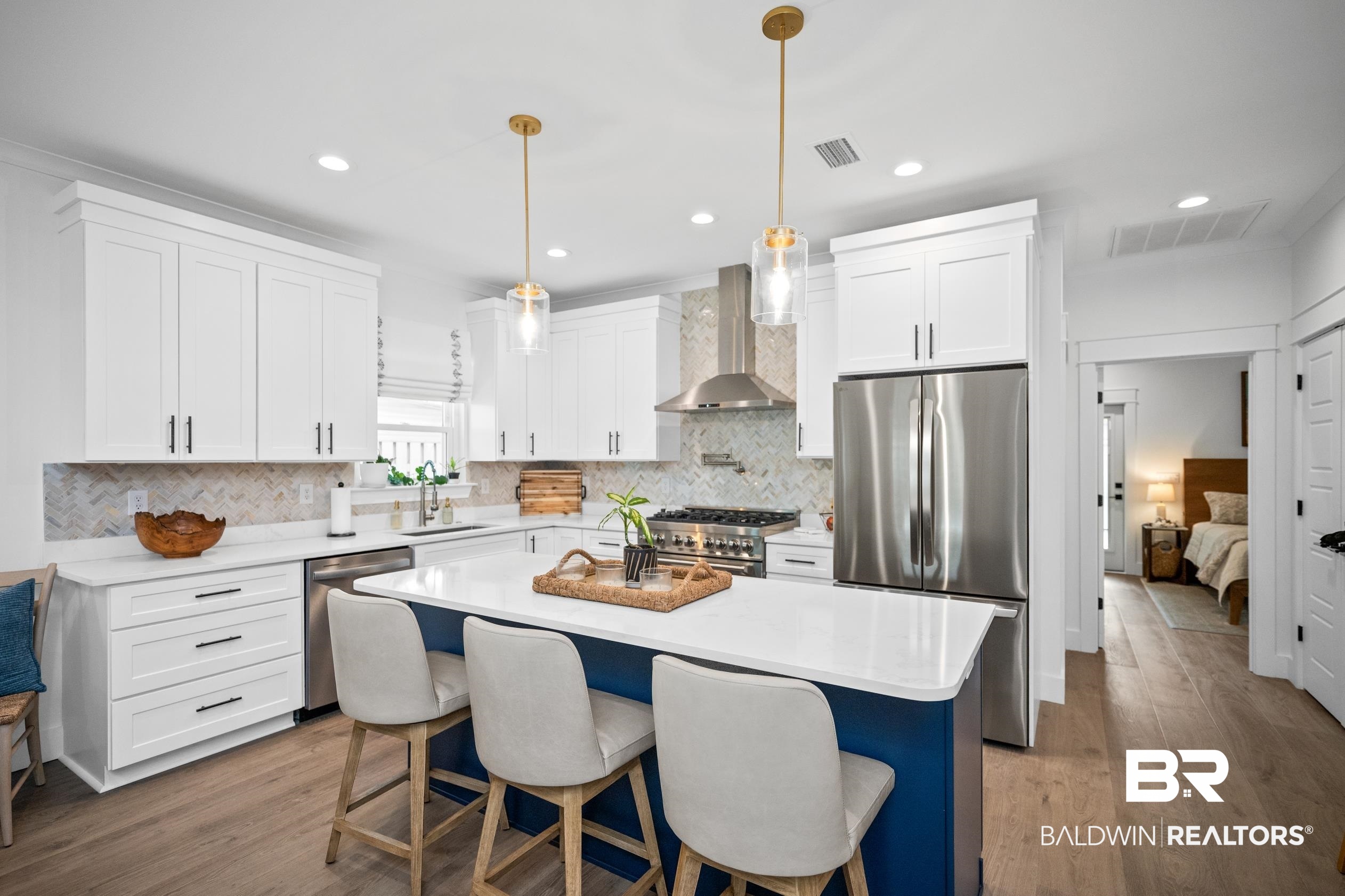 5501 Mobile Avenue Orange Beach, AL 36561 - Photo 6 of 40 Kitchen with stainless steel appliances, wall chimney range hood, wood finished floors, light countertops, and recessed lighting