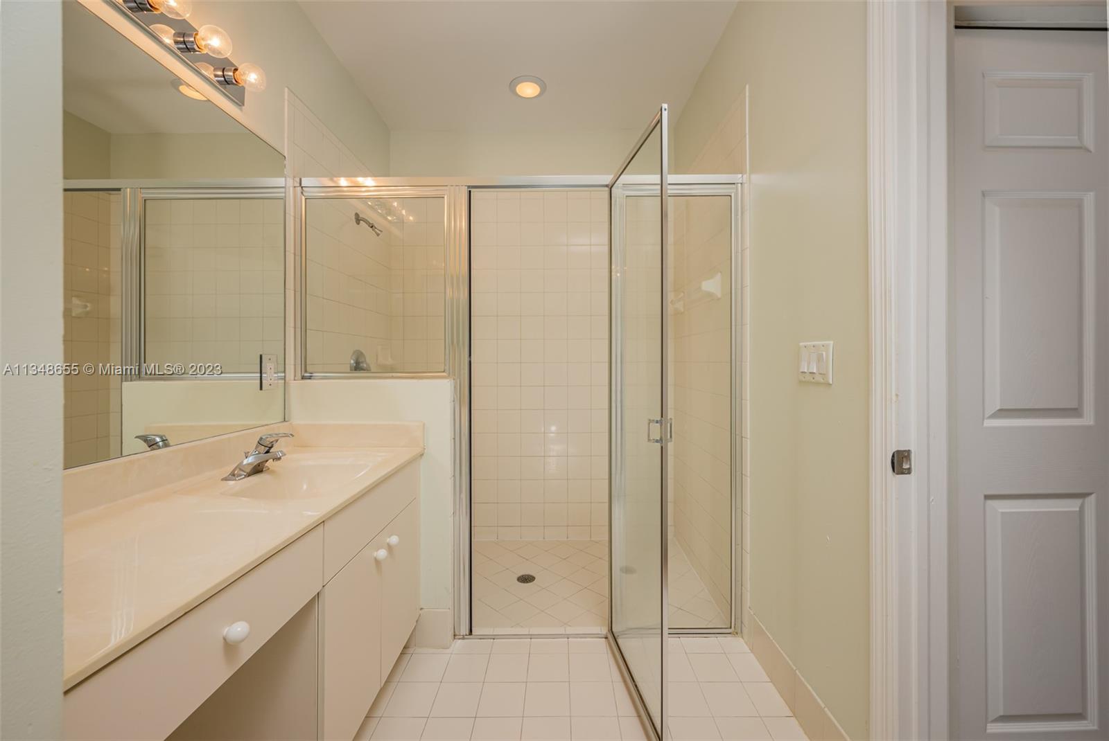 159 Coconut Key Lane Delray Beach, FL 33484 - Photo 22 of 29 a bathroom with a shower sink and mirror