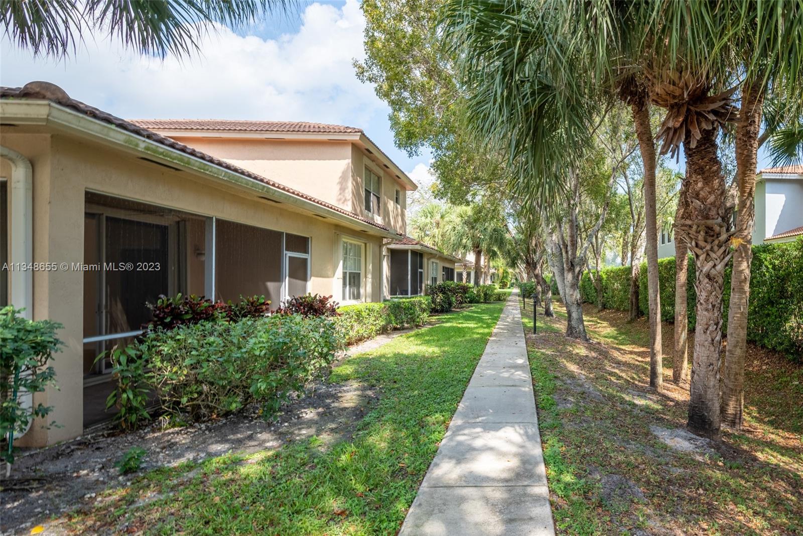 159 Coconut Key Lane Delray Beach, FL 33484 - Photo 25 of 29 front view of a house with a yard and potted plants