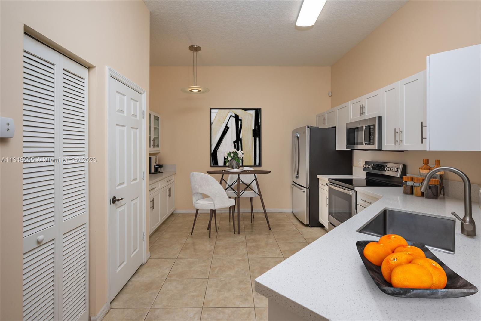 159 Coconut Key Lane Delray Beach, FL 33484 - Photo 5 of 29 a room with stainless steel appliances furniture a rug and a kitchen view