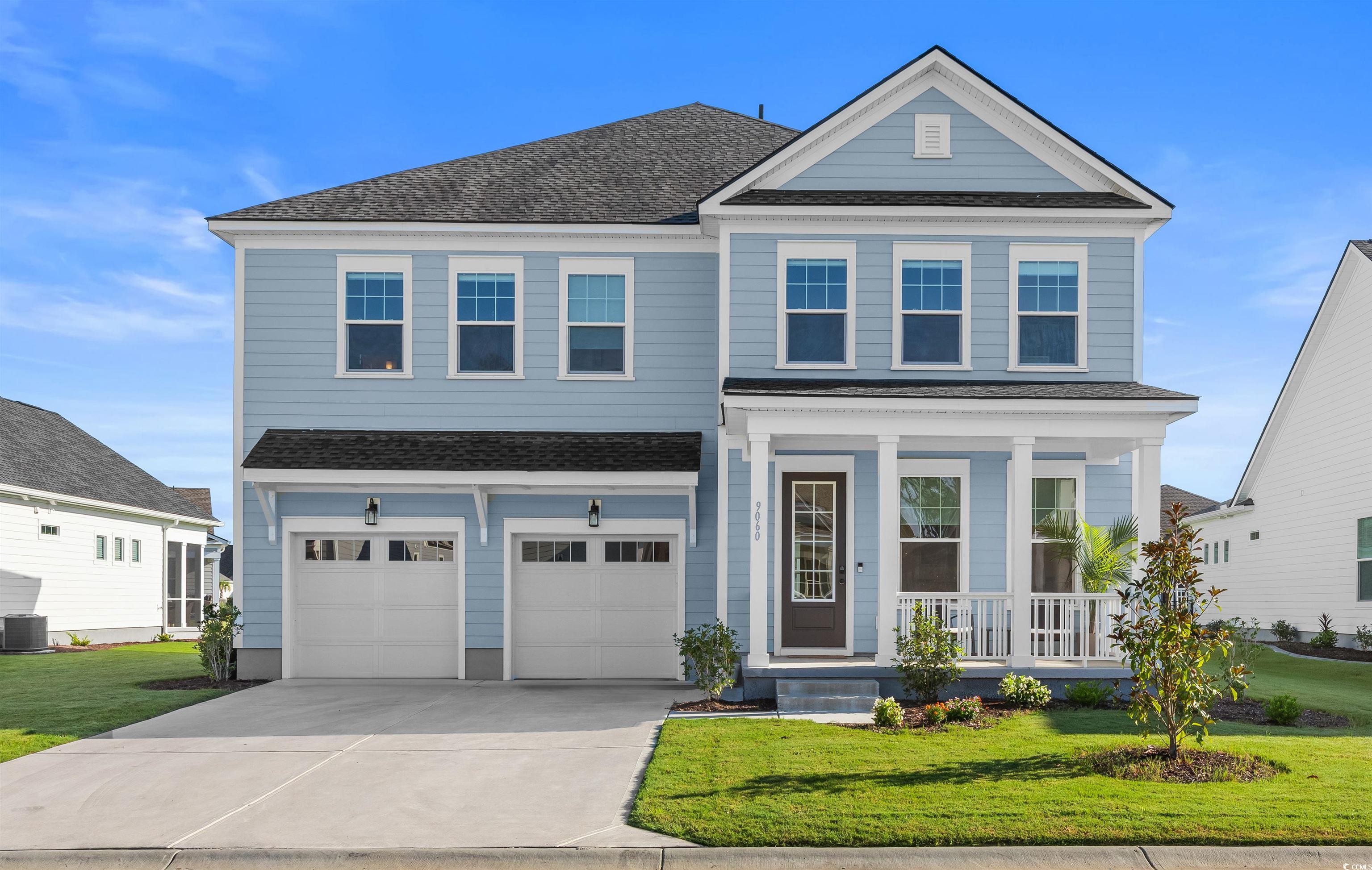 View of front of property with a front lawn, a porch, roof with shingles, driveway, and an attached garage
