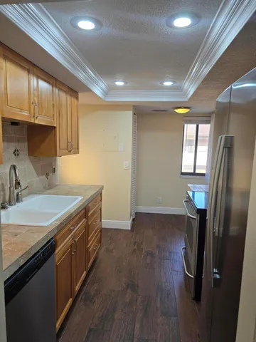 a kitchen with a refrigerator a sink and cabinets