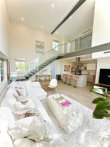 a spacious bedroom with a bed a couch and a flat screen tv