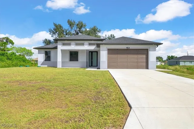 a view of a house with a yard and potted plants