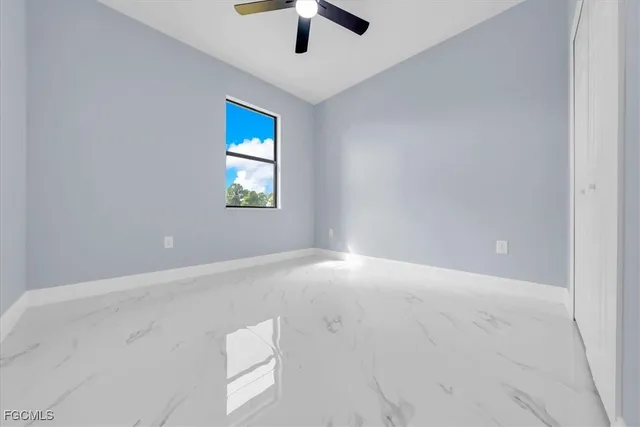 an empty room with windows and fan