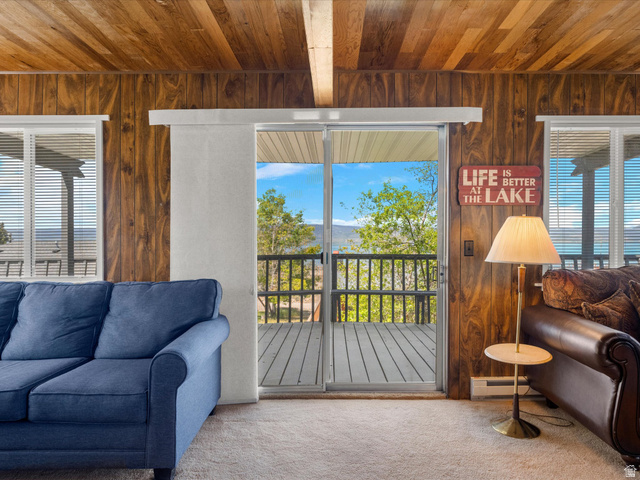 85 B Street, Unit 22 St. Charles, ID 83272 - Photo 16 of 35 Sliding glass door opening to an outdoor deck with a mountain and tree-lined backdrop