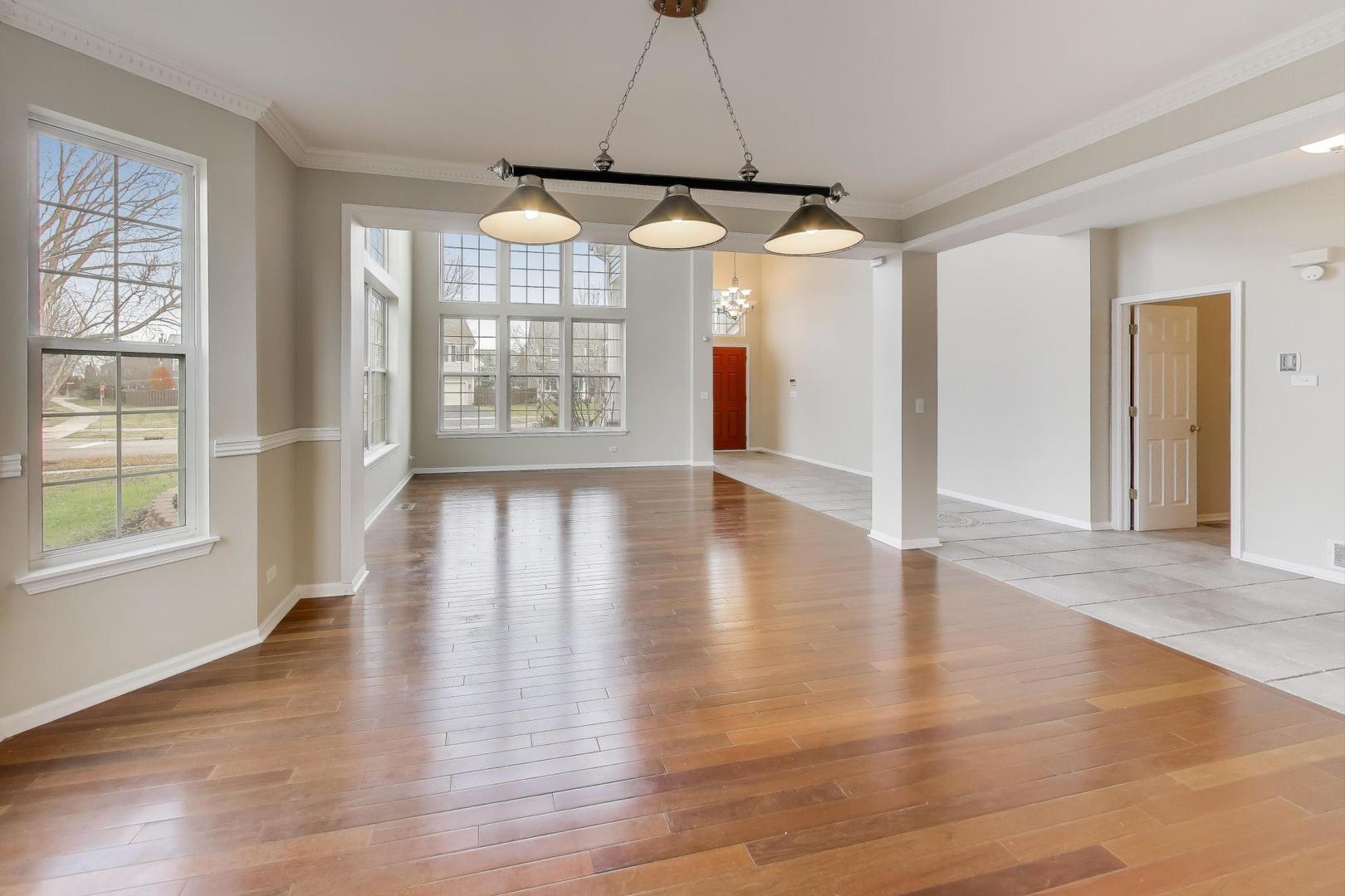 9699 Fairfield Road Huntley, IL 60142 - Photo 11 of 59 an empty room with wooden floor and windows