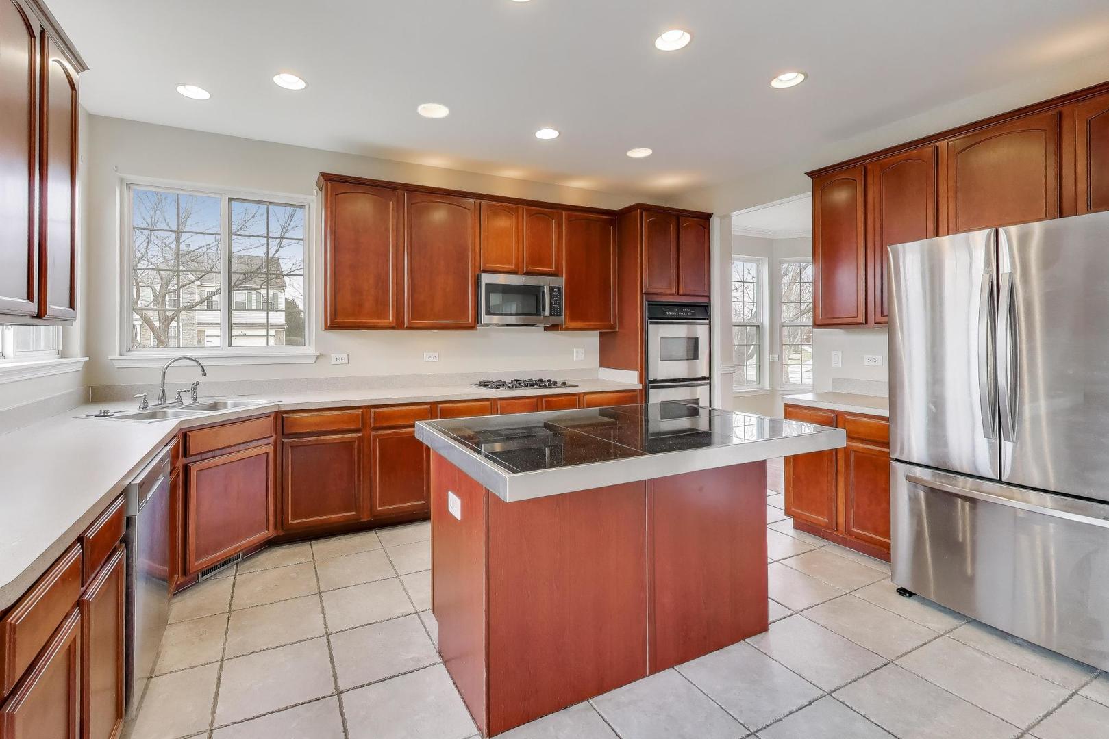 9699 Fairfield Road Huntley, IL 60142 - Photo 13 of 59 a kitchen with stainless steel appliances granite countertop a refrigerator a sink a stove a microwave and island