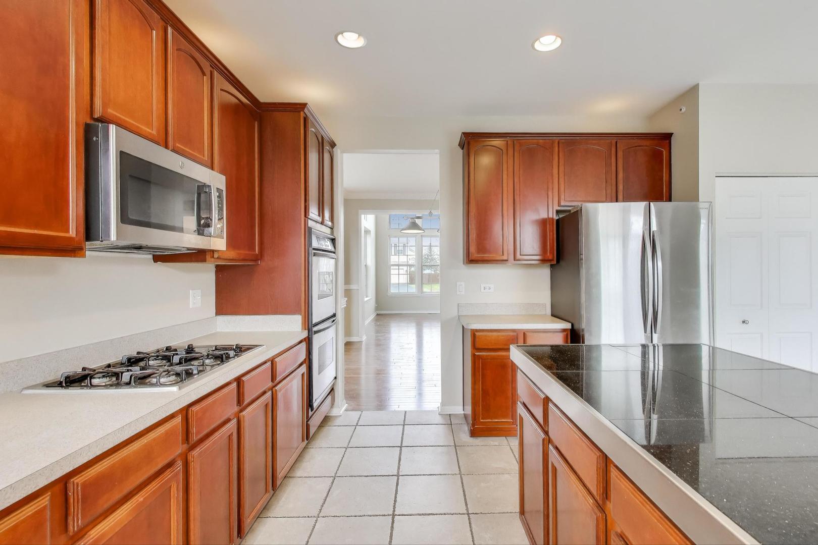 9699 Fairfield Road Huntley, IL 60142 - Photo 14 of 59 a kitchen with stainless steel appliances granite countertop a refrigerator and a stove top oven