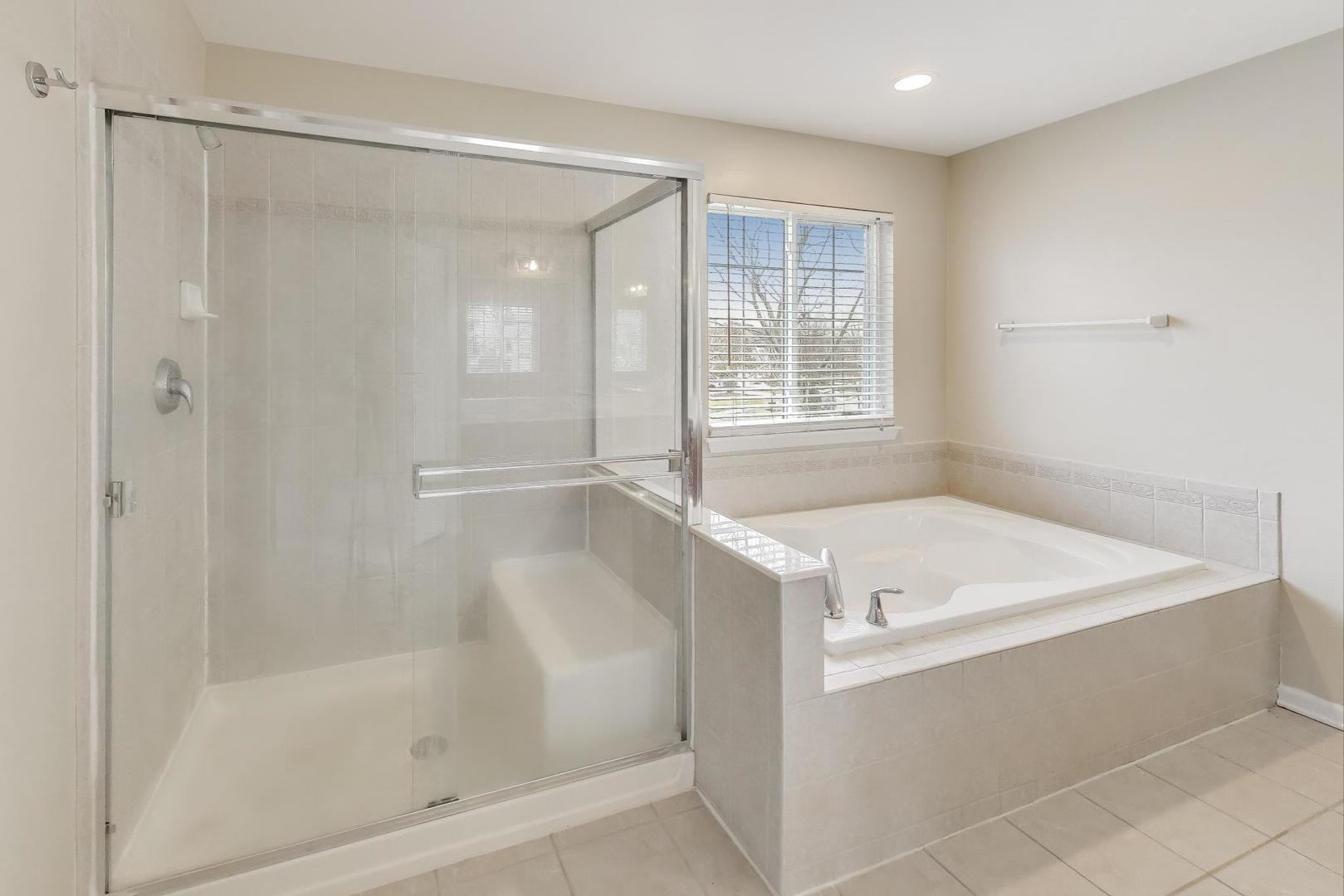 9699 Fairfield Road Huntley, IL 60142 - Photo 29 of 59 a bathroom with a tub a sink and a shower