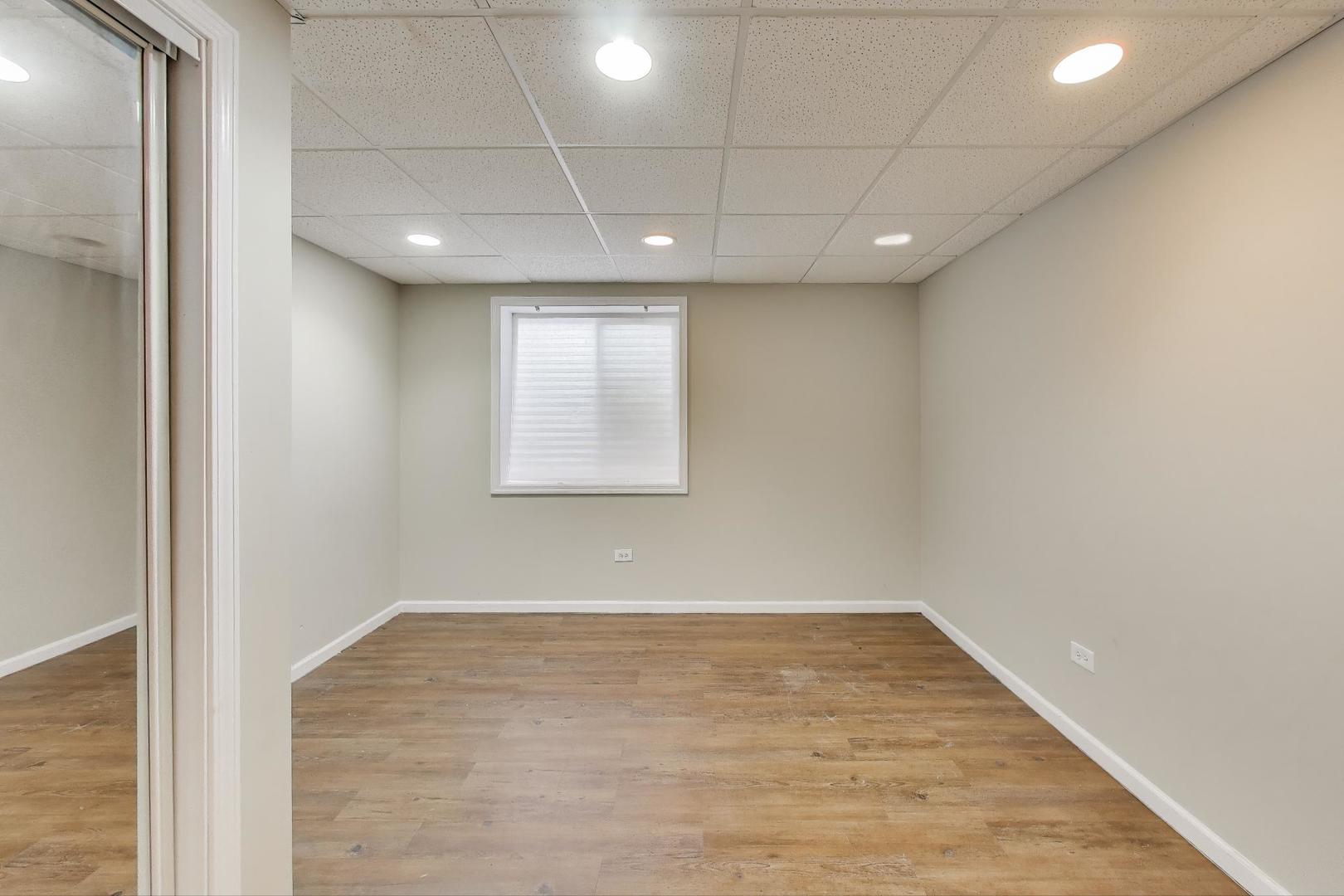 9699 Fairfield Road Huntley, IL 60142 - Photo 47 of 59 an empty room with wooden floor and windows