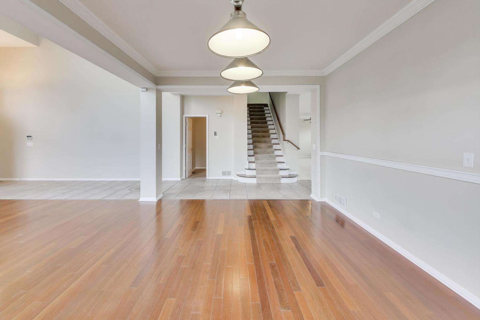 9699 Fairfield Road Huntley, IL 60142 - Photo 9 of 59 a view of empty room with wooden floor and fan