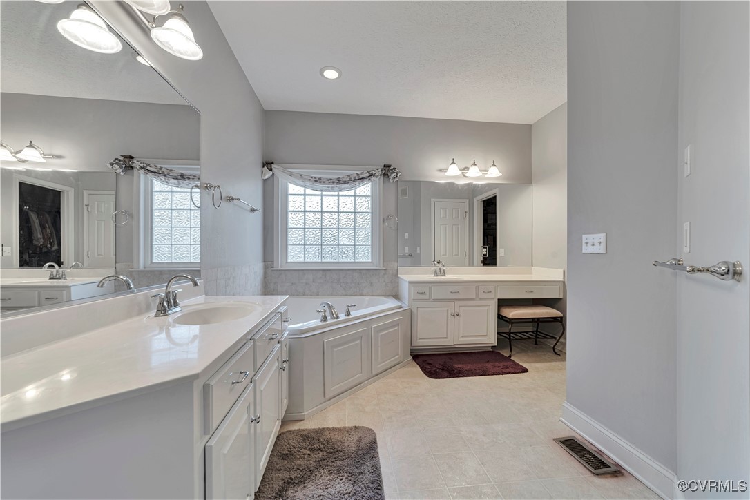 5000 Faraday Drive Chester, VA 23831 - Photo 25 of 40 a large bathroom with a double vanity sink a mirror and a bathtub