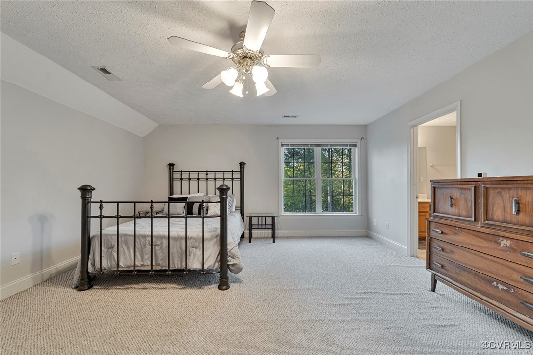5000 Faraday Drive Chester, VA 23831 - Photo 30 of 40 a spacious bedroom with a bed and a chandelier