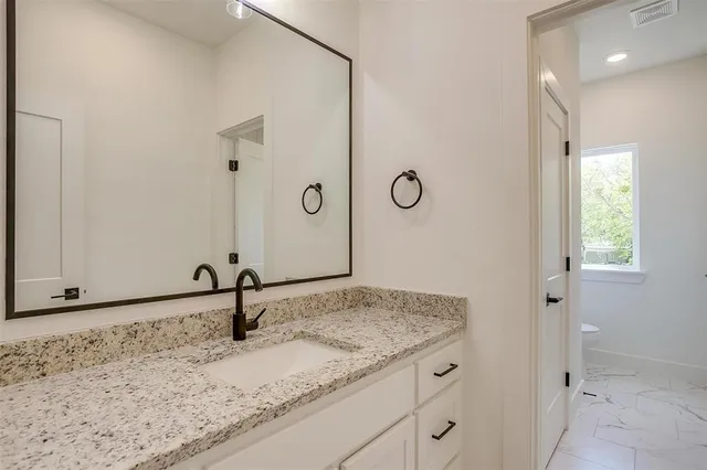 a bathroom with a granite countertop sink and a mirror