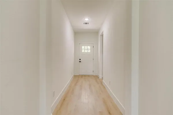 a view of a hallway with wooden floor