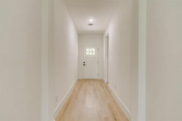 a view of a hallway with wooden floor