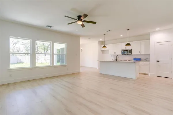 a view of large kitchen with granite countertop stainless steel appliances cabinets a sink and a window