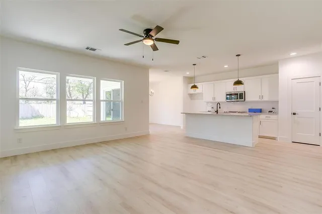 a view of large kitchen with granite countertop stainless steel appliances cabinets a sink and a window